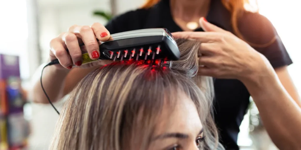 Professional applying red light therapy device for Hair Regrowth Treatment in Birmingham.
