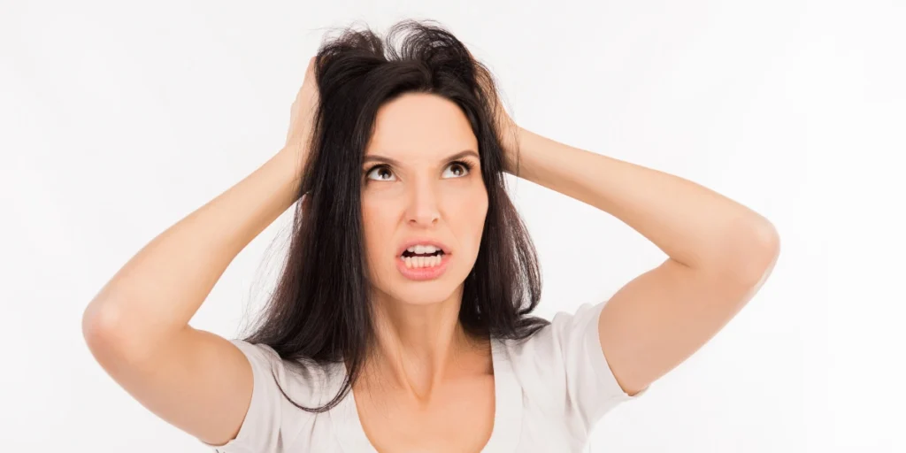 Frustrated woman holding her head showing stress related to Hair loss women UK.