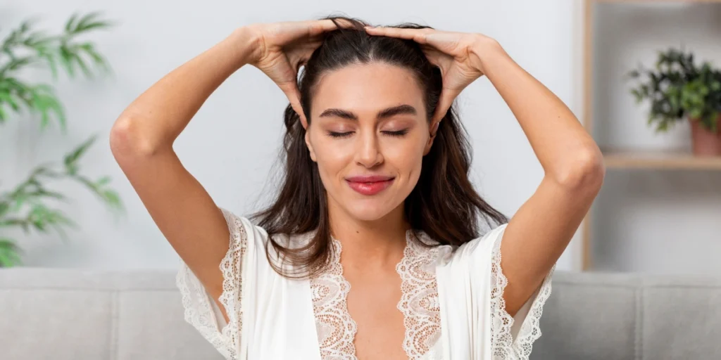 Woman massaging scalp to support hair regrowth with regenerative hair loss treatments UK